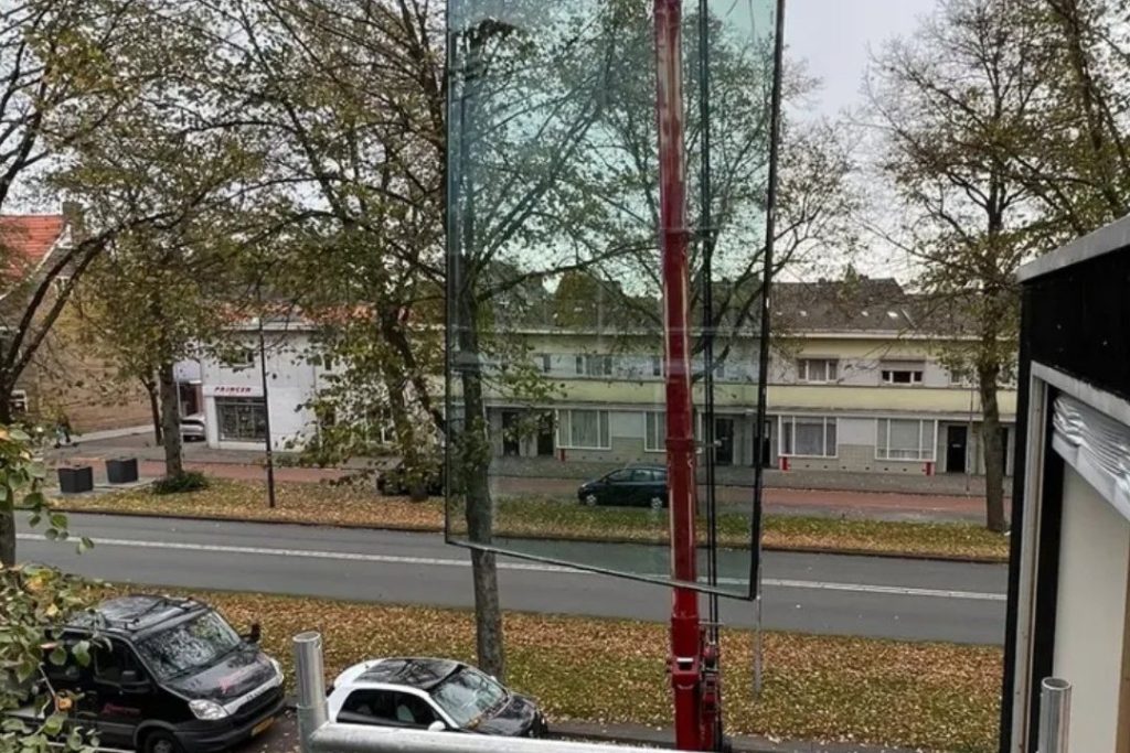 Grote glasplaat wordt voor een woning klaargezet voor plaatsing